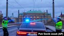 Policía monta guardia en una calle del centro de Praga, este jueves 21 de diciembre de 2023, tras un tiroteo que dejó varios muertos y heridos. (AP Foto/Petr David Josek)